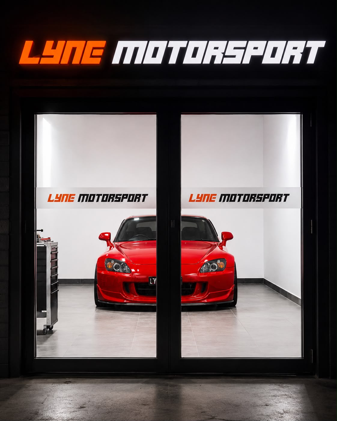 The Lyne Motorsport workshop in Hoppers Crossing lit up at night, a red Honda S2000 inside the glass roller doors